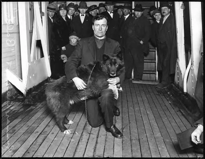 Foto em preto e branco do condutor Gunnar Kaasen ao lado do cão Balto, em Seattle.
